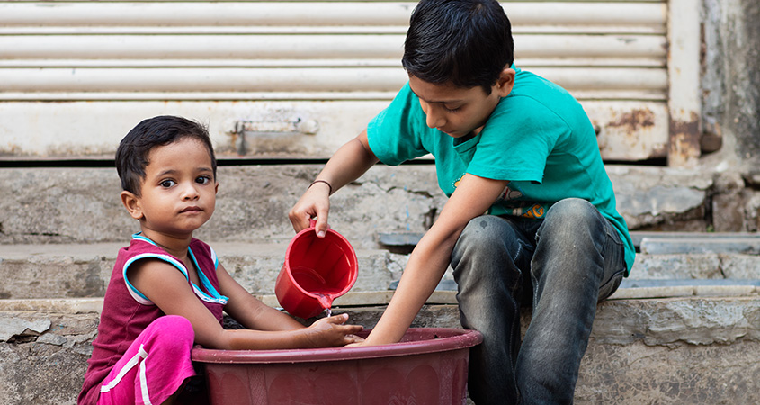 Two kids washing hands in a bowl (photo)