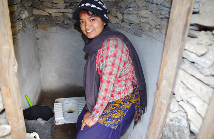 Young woman smiling next to a toilet (photo)